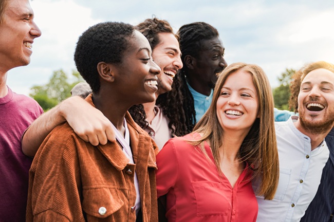 Group of friends having fun celebrating outdoors. Young diverse people enjoy summer vacations together